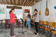Medya donne une leçon de musique. Dans le fonds, un poster de Sakinê, Fidan et Leyla, assassinées à Paris en 2013.