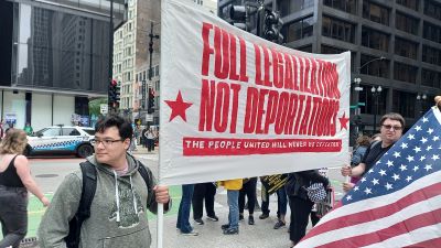  «Régularisations complètes, pas de déportations – Un peuple uni ne sera jamais vaincu», banderole au sein d'une manifestation No Kings à Chicago.